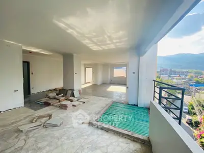 Spacious unfinished apartment with balcony and scenic mountain view.