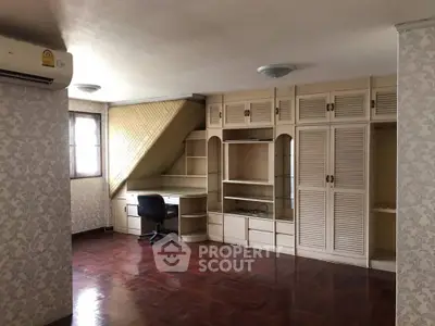 Spacious study room with built-in shelves and wooden flooring
