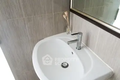 Modern bathroom sink with sleek faucet and neutral tile design