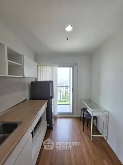 Modern kitchen with sleek design and balcony view in high-rise apartment