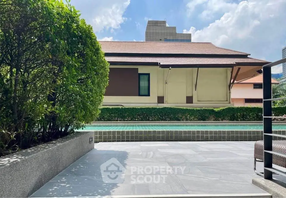Charming outdoor pool area with lush greenery and modern design, perfect for relaxation and leisure.