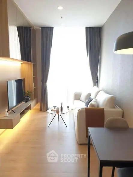 Modern living room with sleek furniture and large window, perfect for urban living.