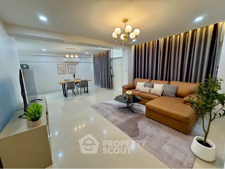 Spacious modern living room with elegant decor and open dining area, perfect for entertaining.