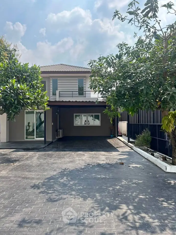 Charming two-story house with spacious driveway and lush greenery