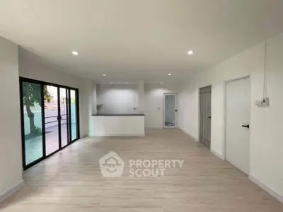 Spacious modern living room with open layout and large sliding glass doors to balcony.