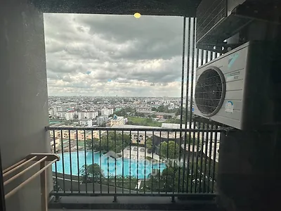 Stunning high-rise balcony view with cityscape and pool, featuring air conditioning unit.