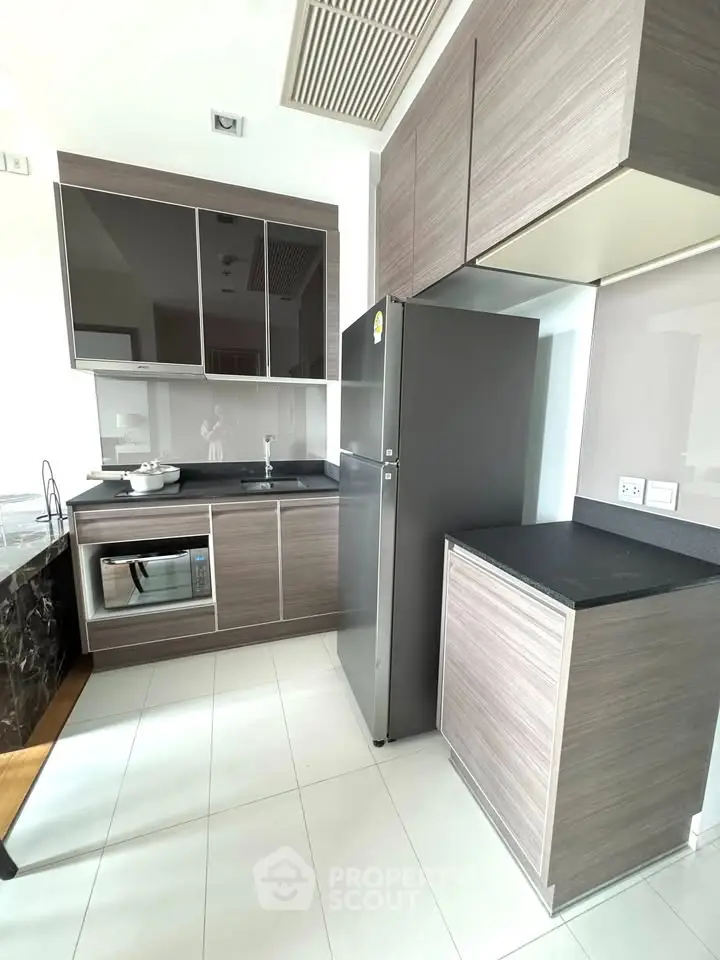 Modern kitchen with sleek cabinetry and stainless steel appliances in a stylish apartment.