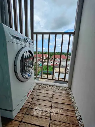 Charming balcony with washing machine and scenic view, perfect for urban living convenience.