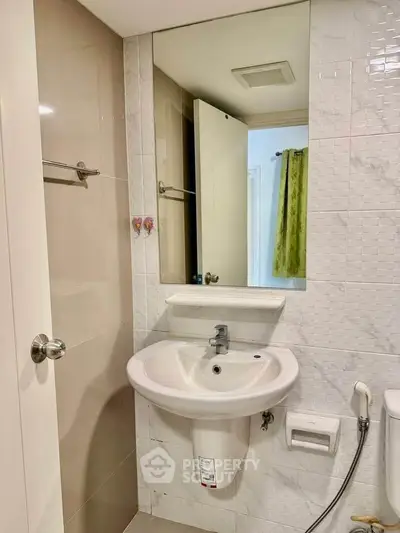 Modern bathroom with sleek sink and large mirror in a stylish apartment.