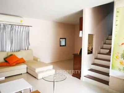 Spacious living room with modern decor and staircase in a stylish home