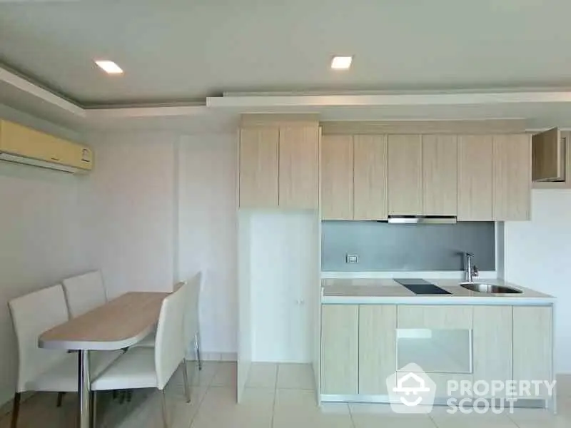 Modern kitchen with sleek cabinetry and dining area in stylish apartment