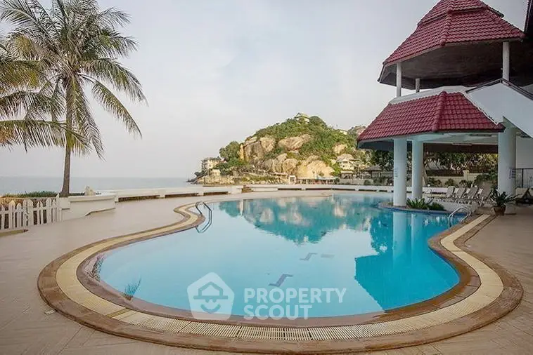 Stunning beachfront pool with ocean view and tropical landscaping, perfect for luxury living.