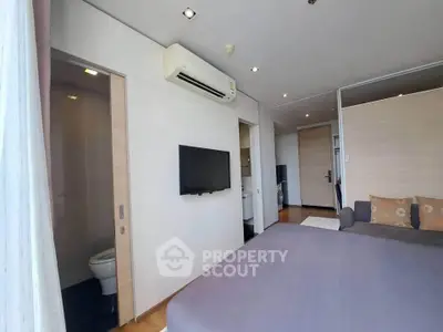 Modern bedroom with air conditioning and ensuite bathroom in a stylish apartment.