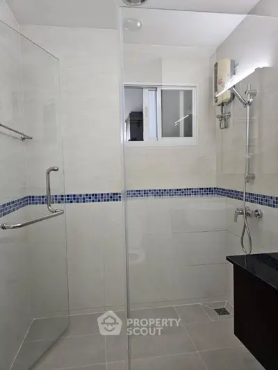 Modern bathroom with glass shower and sleek fixtures in a contemporary home.