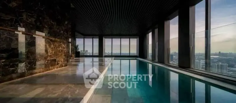 Luxurious indoor pool with panoramic city views and elegant marble design.