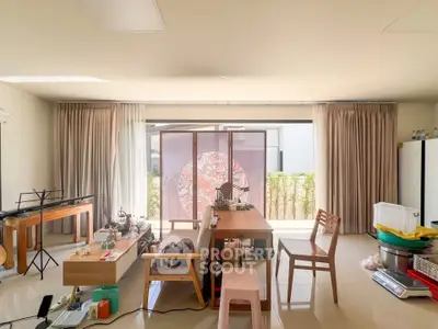 Spacious living room with large windows and modern furniture, perfect for family gatherings.
