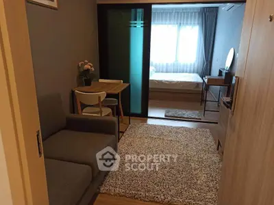 Cozy apartment with modern living room and bedroom separated by sliding glass doors.