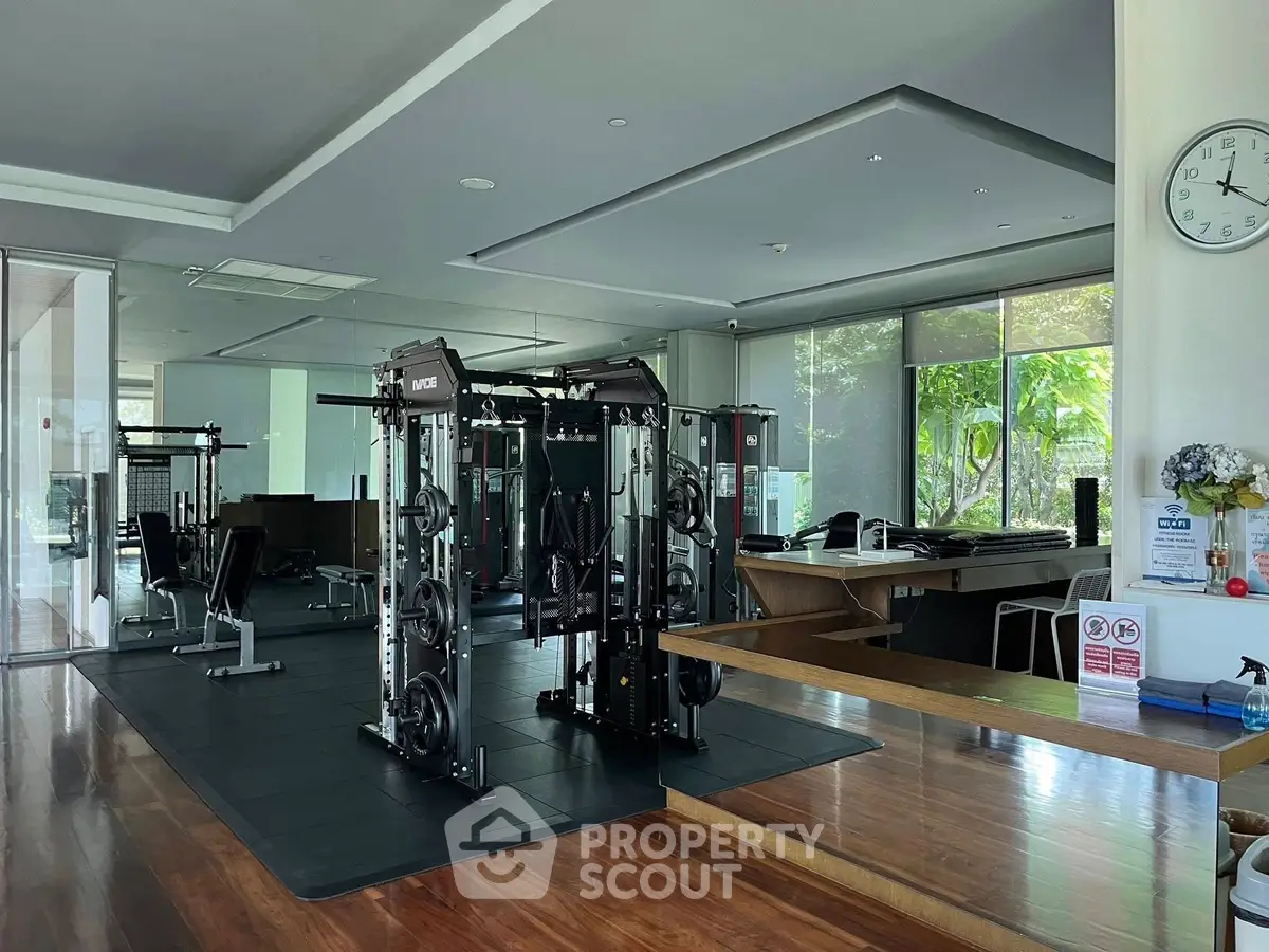 Modern gym with state-of-the-art equipment and large windows offering garden views.