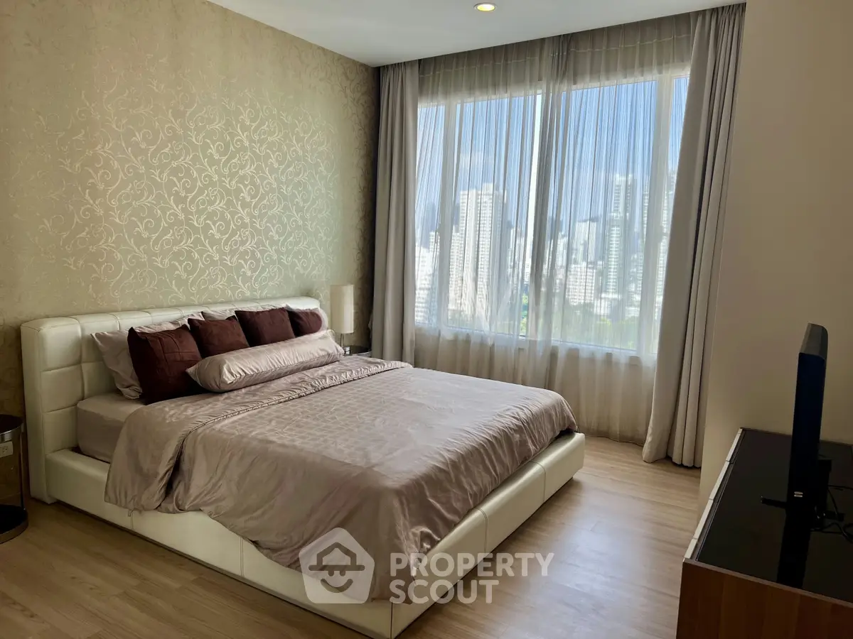 Luxurious bedroom with city view, featuring elegant decor and natural light.