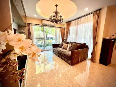 Luxurious living room with elegant chandelier and plush sofa, featuring large windows and marble flooring.