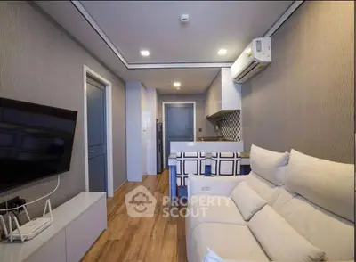 Modern living room with cozy sofa and open kitchen layout, featuring stylish decor and wooden flooring.