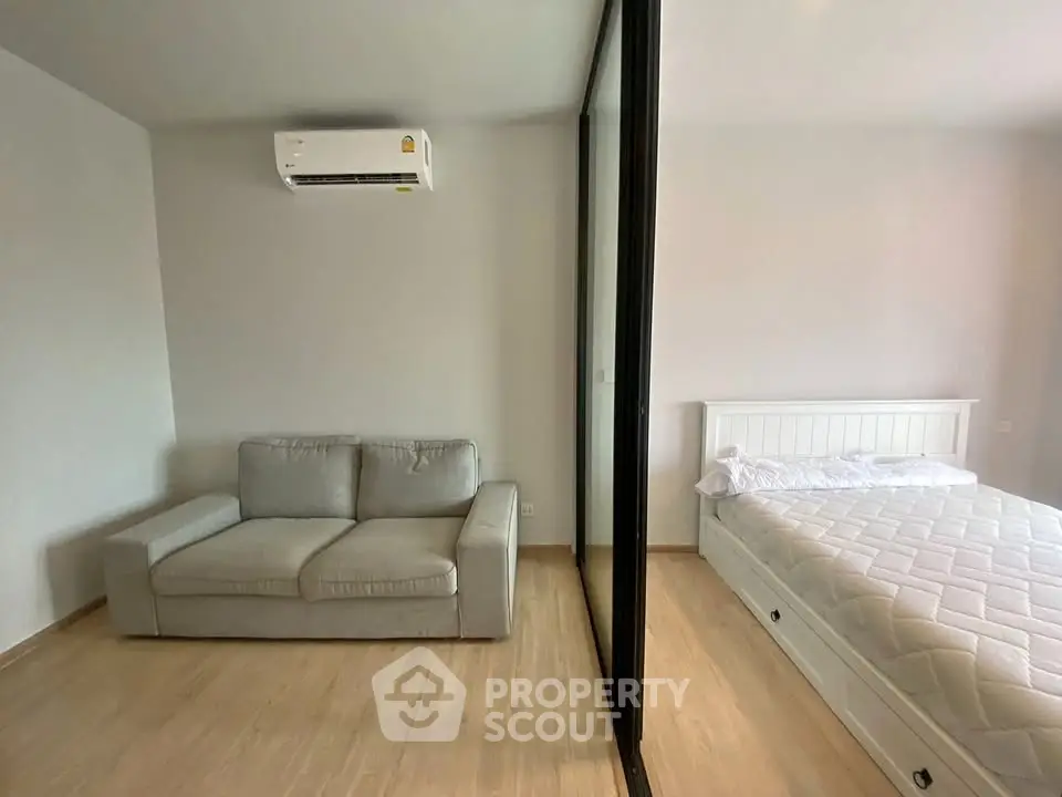 Modern bedroom with cozy sofa and air conditioning in a stylish apartment