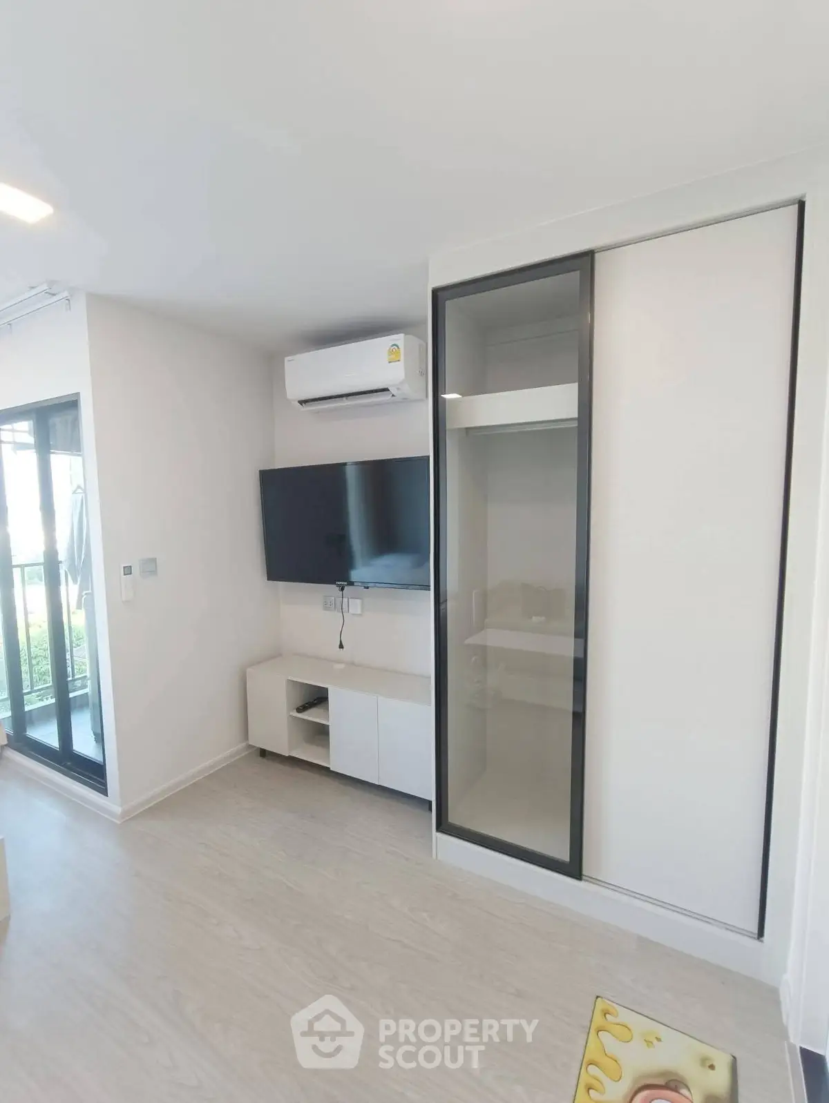 Modern living room with sleek TV setup and sliding wardrobe doors