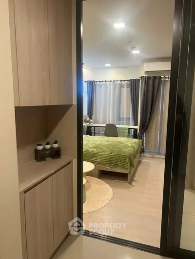 Modern bedroom with stylish decor and natural light, featuring a cozy bed and elegant curtains.
