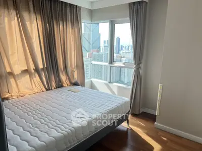 Modern bedroom with city view and large windows in high-rise apartment