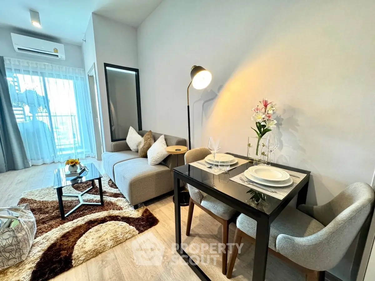 Modern living room with cozy seating and dining area, featuring stylish decor and natural light.