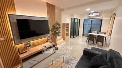 Modern living room with sleek design, featuring a large TV, stylish furniture, and elegant dining area.