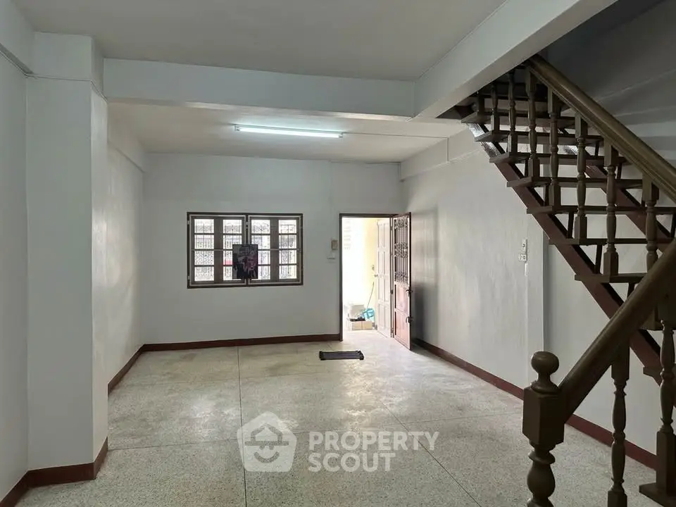 Spacious interior with staircase and natural light, ideal for customization.