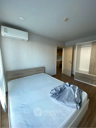 Modern bedroom with air conditioning and wooden flooring