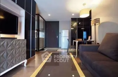 Modern living room with sleek furniture and open kitchen layout in stylish apartment.