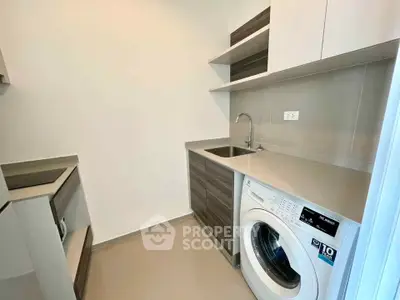 Modern kitchen with sleek cabinetry and built-in washing machine