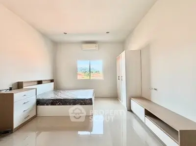 Spacious minimalist bedroom with large window and modern furniture