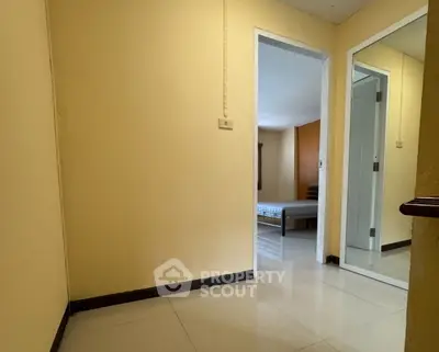 Spacious interior hallway leading to a cozy bedroom with modern furnishings.