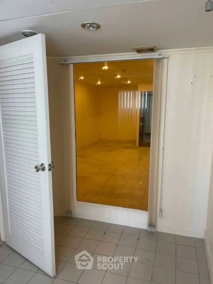 Spacious interior with tiled flooring and open door, ideal for versatile use.