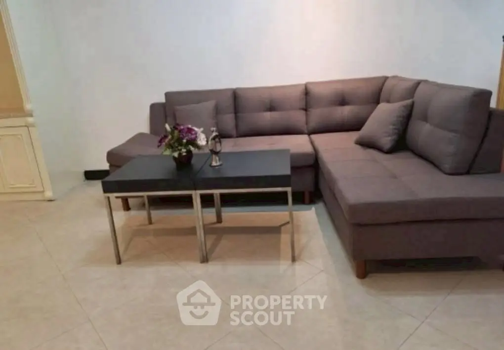Modern living room with stylish gray sectional sofa and sleek coffee table.