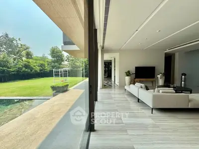 Luxurious living room with pool view and modern decor in a spacious open layout.