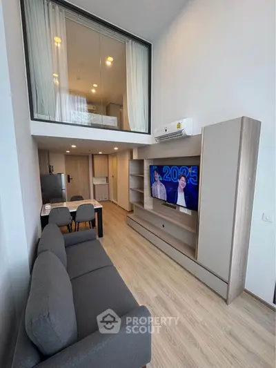 Modern loft-style living room with high ceiling and sleek furnishings