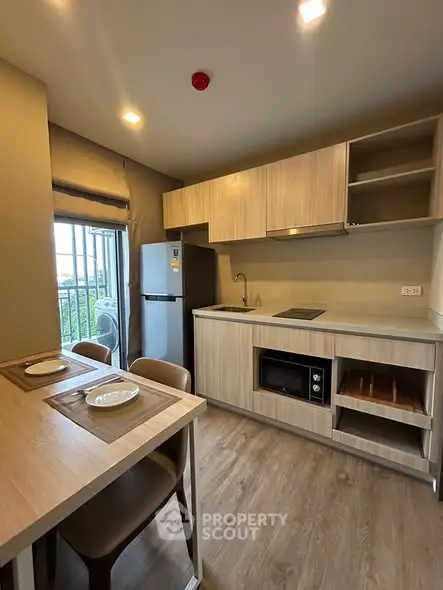 Modern kitchen with sleek cabinetry and integrated appliances in a cozy apartment setting.