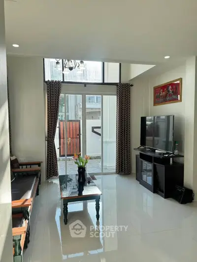 Spacious living room with high ceilings, large windows, and modern decor in a bright, inviting home.