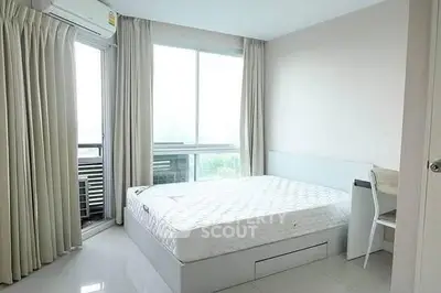 Bright bedroom with large window and modern furnishings in a stylish apartment.