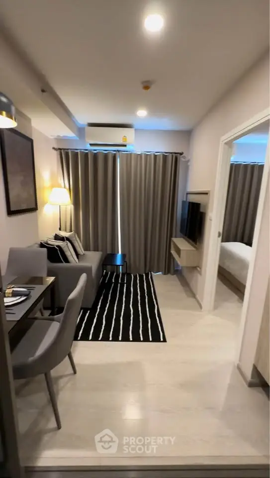 Modern living room with cozy seating and stylish decor in a compact apartment.