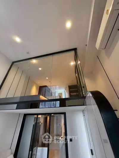 Modern loft apartment with sleek glass mezzanine and stylish lighting