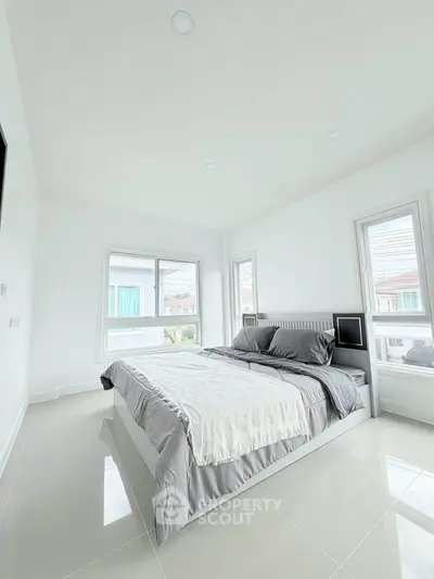 Bright and spacious bedroom with modern decor and large windows in a contemporary home.