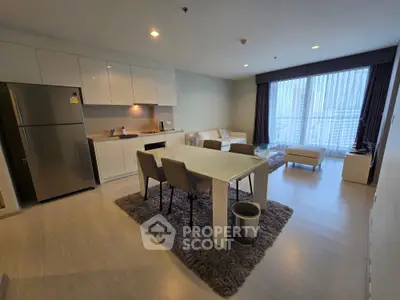 Modern open-layout living room with dining area and large windows offering city views.