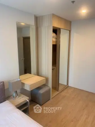 Modern bedroom with wooden flooring and built-in wardrobe in a stylish apartment.