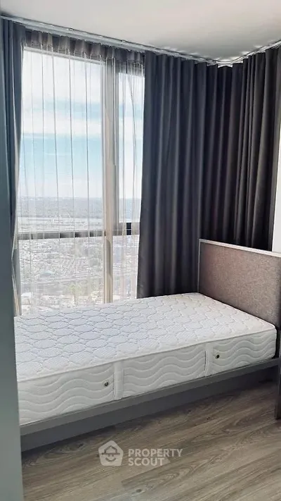 Modern bedroom with large window offering stunning city view, featuring sleek design and natural light.